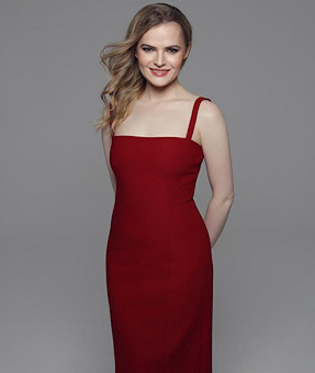 Fair skinned smiling blond girl in a red dress