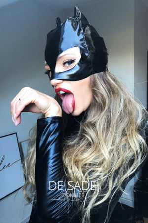 Blonde Mistress in a PVC cat suit licking her paws
