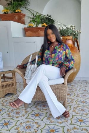 Sexy ebony independent in white trousers and a colourful shirt
