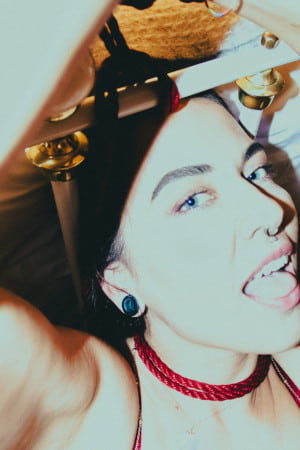 Close up of a blue-eyed brunette with a nose piercing