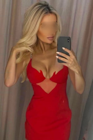 Blonde girl in a red dress taking a selfie