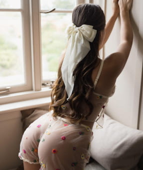 Long haired brunette in white panties with flowers stiching