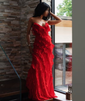 Elegant exotic woman in a stylish long red dress
