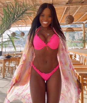 Very beautiful ebony girl in a pink bikini smiling brightly
