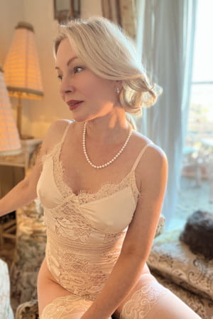 Elegant petite blonde mature woman in cream lingerie